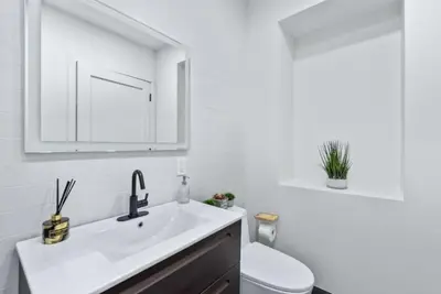 a white bathroom with a sink and a toilet at Top Notch 2 Bedroom Minutes From Central Park in New York