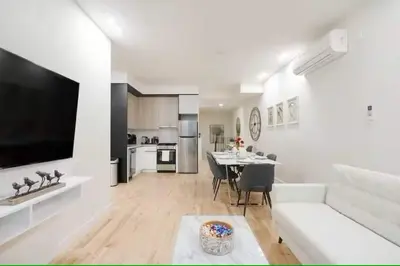 a kitchen and living room with a table and a couch at Luxury 2BR Duplex 5min to Central Park in New York