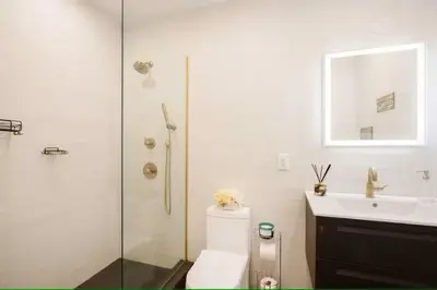 a bathroom with a toilet and a sink and a shower at Luxury 2BR Duplex 5min to Central Park in New York