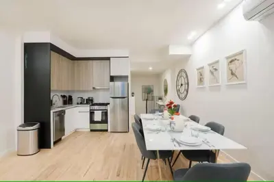 a kitchen and dining room with a white table and chairs at Luxury 2BR Duplex 5min to Central Park in New York