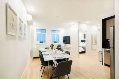 a dining room and living room with a table and chairs at Luxury 2BR Duplex 5min to Central Park in New York