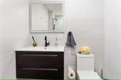 a bathroom with a sink and a mirror at Luxury 3BR Duplex w Private Patio in Upper East in New York