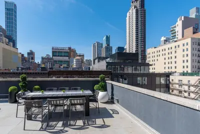 a table and chairs on a balcony with a city skyline at 3BR Penthouse Suite with Massive Private Rooftop in New York