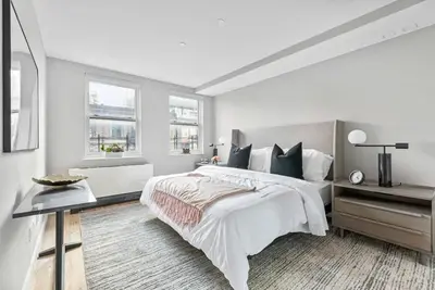 a white bedroom with a large bed and a desk at 3BR Penthouse Suite with Massive Private Rooftop in New York