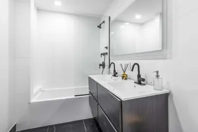 a white bathroom with a sink and a bath tub at 3BR Penthouse Suite with Massive Private Rooftop in New York