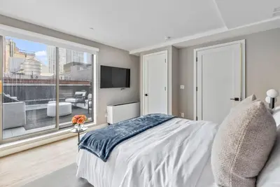 a bedroom with a bed and a large window at 3BR Penthouse Suite with Massive Private Rooftop in New York