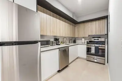 a kitchen with white cabinets and stainless steel appliances at 3BR Penthouse with Massive Private Rooftop in New York