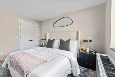 a bedroom with a large white bed and a mirror at 3BR Penthouse with Massive Private Rooftop in New York