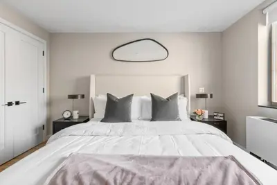a bedroom with a large white bed with gray pillows at 3BR Penthouse with Massive Private Rooftop in New York