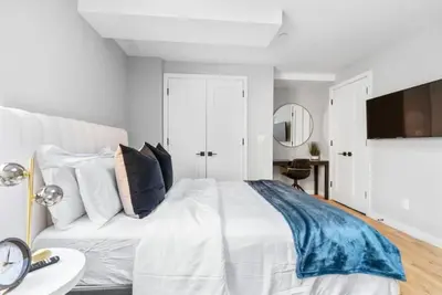 a bedroom with a white bed and a white couch at 3BR Penthouse with Massive Private Rooftop in New York
