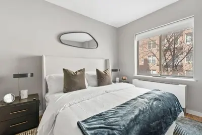 a bedroom with a large bed and a window at Top Notch 2BR in Upper East Mins to Central Park in New York