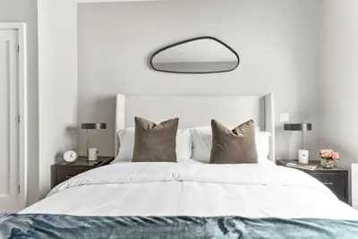 a bedroom with a large white bed with pillows at Top Notch 2BR in Upper East Mins to Central Park in New York
