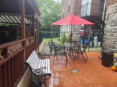 a patio with a table and chairs and an umbrella at Lovely 2 bedroom Apartment with 2 Entrance and Parking with a fee in University Heights