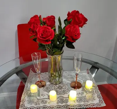 a vase with red roses and candles on a table at Lovely 2 bedroom Apartment with 2 Entrance and Parking with a fee in University Heights