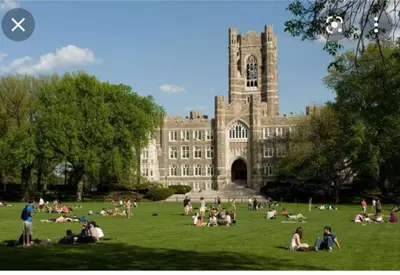 a group of people sitting on the grass in front of a building at Lovely 2 bedroom Apartment with 2 Entrance and Parking with a fee in University Heights