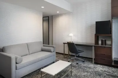 a living room with a couch and a desk at DoubleTree by Hilton Long Island City, NY in Long Island City