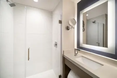a bathroom with a sink and a mirror at DoubleTree by Hilton Long Island City, NY in Long Island City