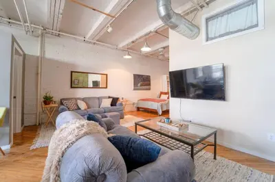 a living room with a couch and a table at Cool Urban Stay Dtwn Apt And Patio in Binghamton