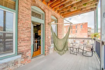 a hammock on the balcony of a house at Cool Urban Stay Dtwn Apt And Patio in Binghamton