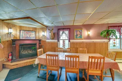 a dining room with a table and a fireplace at Lanesville Home with Pool Table, Bar and Deck! in Lanesville