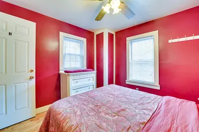a red bedroom with a bed and two windows at Lanesville Home with Pool Table, Bar and Deck! in Lanesville