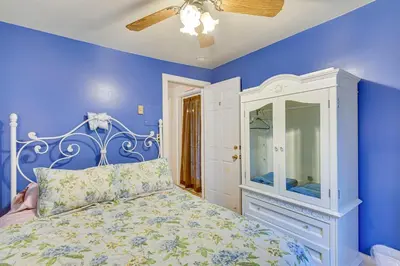 a blue bedroom with a bed and a white cabinet at Lanesville Home with Pool Table, Bar and Deck! in Lanesville