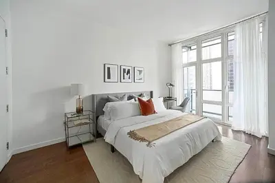 a white bedroom with a large bed and a window at Times Square Penthouse in New York