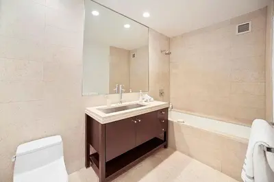 a bathroom with a sink and a toilet and a mirror at Times Square Penthouse in New York