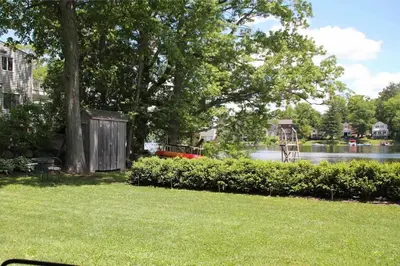 a park with a view of a river and a tree at Waterfront Home on Bantam Lake with Private Beach in Morris
