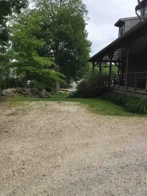 a gravel driveway next to a house with a porch at Waterfront Home on Bantam Lake with Private Beach in Morris