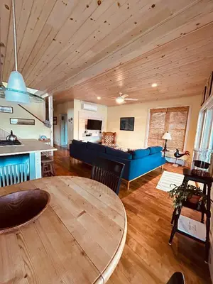 a living room with a table and a blue couch at Waterfront Home on Bantam Lake with Private Beach in Morris
