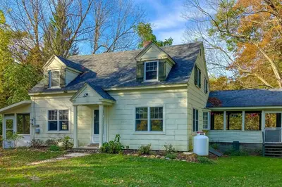 a white house with a blue roof at Green Mountain Retreat in Sunderland