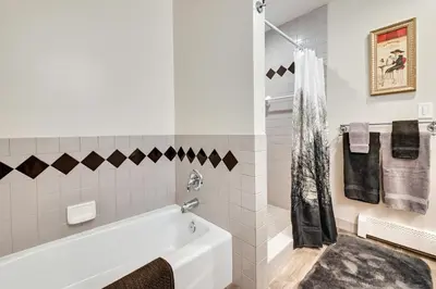 a white bathroom with a tub and a shower at Quiet Killingworth Rental with Deck and Grill! in Deep River