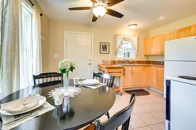 a kitchen and dining room with a table and a refrigerator at Quiet Killingworth Rental with Deck and Grill! in Deep River
