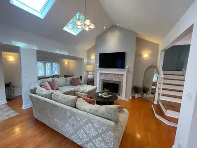 a living room with a couch and a fireplace at Jersey home, close to New York City fun! in Englewood