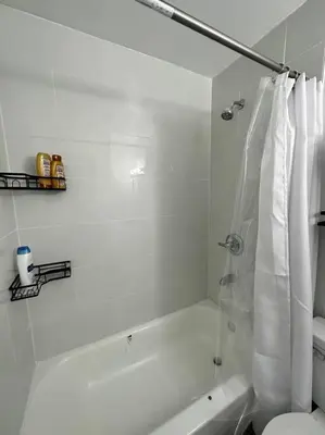 a white bathroom with a tub and a toilet at GREAT VALUE Stylish Queen Beds WD Free Park in Schenectady