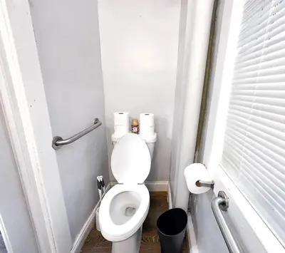 a small bathroom with a toilet with rolls of toilet paper at GREAT VALUE 7 Beds WD Parking in Albany