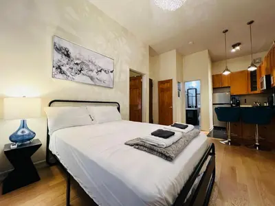 a bedroom with a large bed with white sheets at Steps from Empire State Building in New York