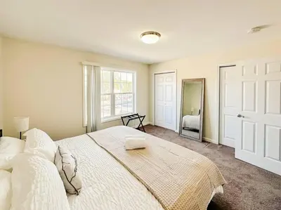 a bedroom with a large white bed and a mirror at Luxury Style 2 King Bed WD FREE Garage in Schenectady