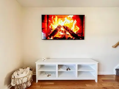a living room with a fire on the wall at Luxury Style 2 King Bed WD FREE Garage in Schenectady