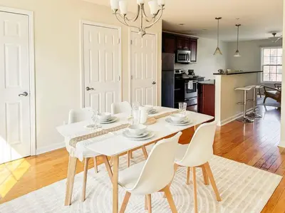 a dining room with a white table and chairs at Luxury Style 2 King Bed WD FREE Garage in Schenectady