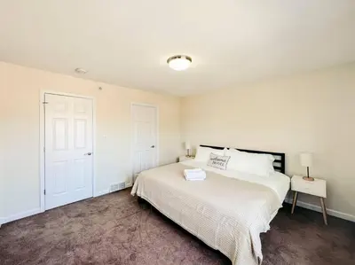 a white bedroom with a bed and a white door at Luxury Style 2 King Bed WD FREE Garage in Schenectady