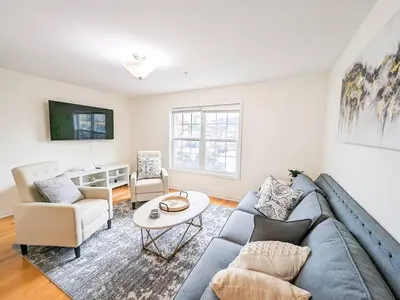 a living room with a couch and a table at Luxury Stylish Townhome King Beds WD Garage in Schenectady