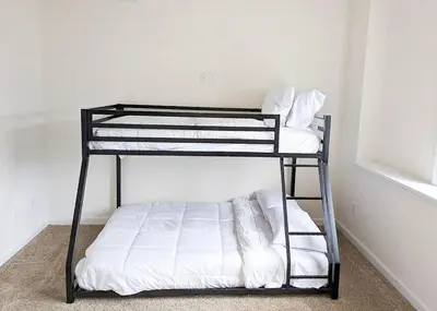 a black bunk bed with white sheets on it at Luxury Stylish Townhome King Beds WD Garage in Schenectady