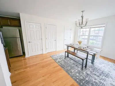 a dining room with a table and a refrigerator at Luxury Stylish Townhome King Beds WD Garage in Schenectady