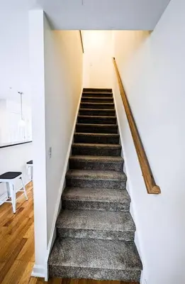 a staircase in a home with white walls and wooden floors at Luxury Stylish Townhome King Beds WD Garage in Schenectady