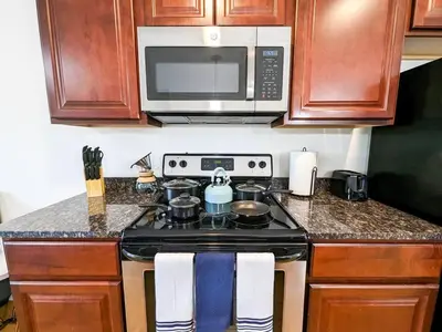 a kitchen with a stove and a microwave at Luxury Stylish Townhome King Beds WD Garage in Schenectady