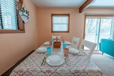 a dining room with a table with dishes on it at PoconoChalet-Hot Tub-Grill-Firepit-Games in Long Pond