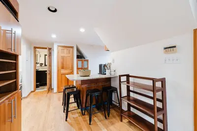 a kitchen with a counter and some stools at Private estate apartment. in Glen Head