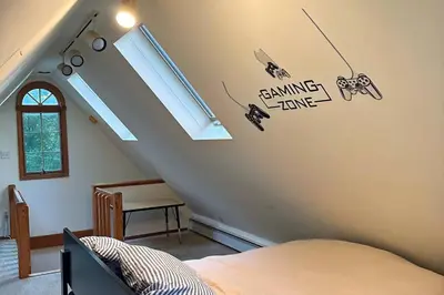 a bedroom with a staircase with a bed and a window at Private estate apartment. in Glen Head